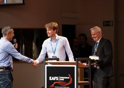 Professor Arian van Asten and Dr. Emil Hjalmarsson congratulating and presenting Jeroen Bergers as winner of Best Student Poster Award at the Closing Ceremony. Photo by Marcus Andrae.
